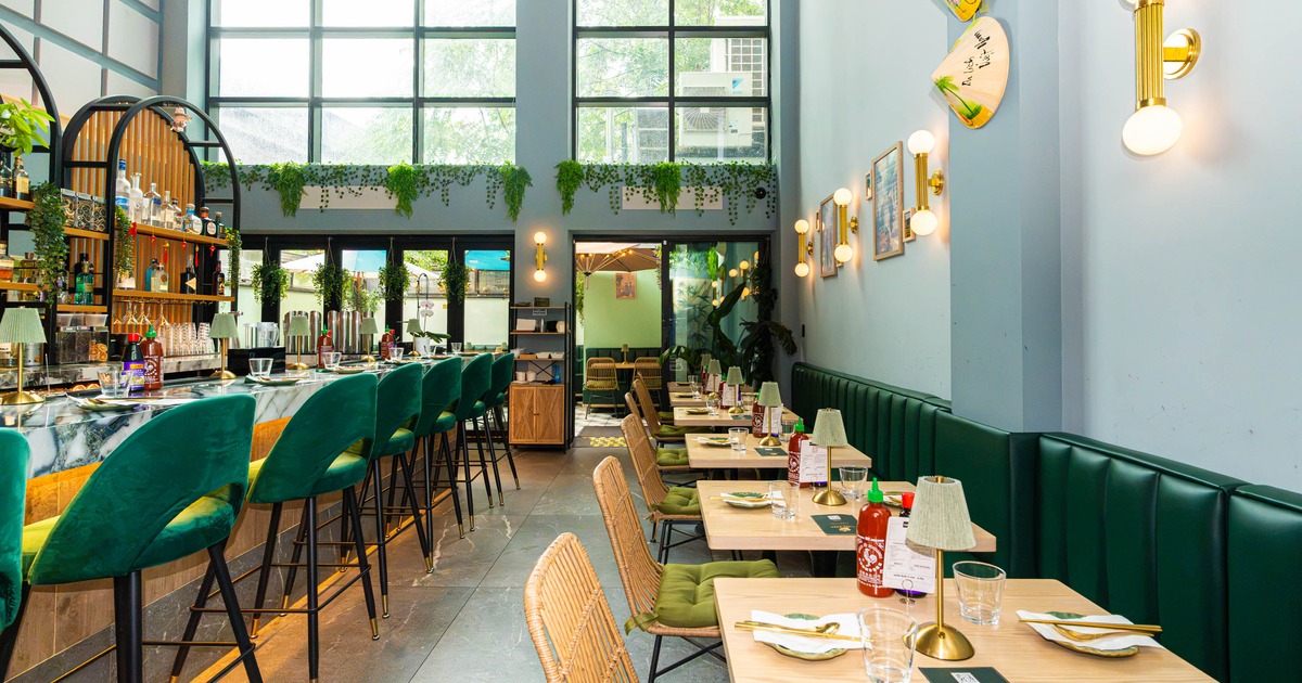 Interior seating area with a marble bar and green velvet stools