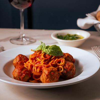 Spaghetti with meatballs, tomato sauce, and basil garnish.
