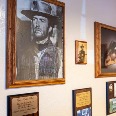 Framed western-themed memorabilia displayed on a wall.