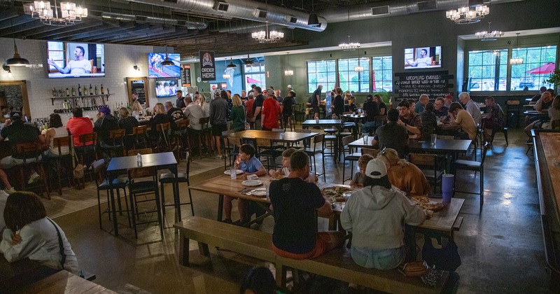 Interior, bar and seating area full of guests enjoying their food and drinks