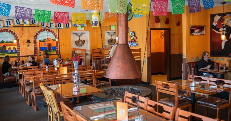 Interior seating area with wooden chairs and tables, colorful decoration