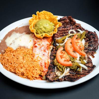 Grilled steak with rice, beans, guacamole, and red cheese enchiladas.