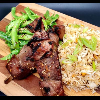 Grilled skewered meat, served with green beans and  fried rice.
