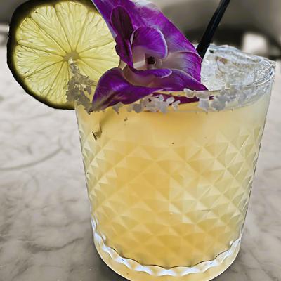 Yellow drink with salt rim, lime and orchid.