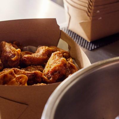 Crispy fried chicken served in a cardboard takeout box.