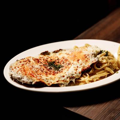 Chicken Parmigiana served with a side of Fettuccini Oleo.