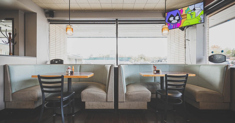Interior, two half circle dining booths with tables and chairs