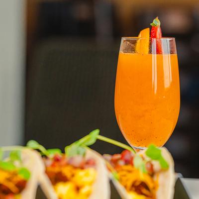 Fiesta tacos and a glass of strawberry orange juice.