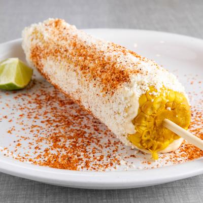 Corn cob coated with cheese and red seasoning.