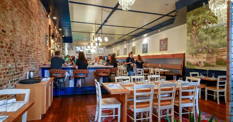 Warm and cozy restaurant interior, dining area, and bar with guests