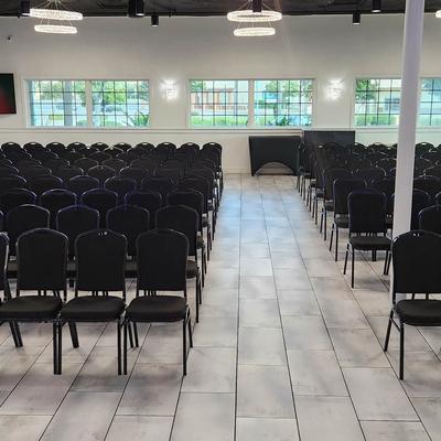A room featuring rows of black chairs.