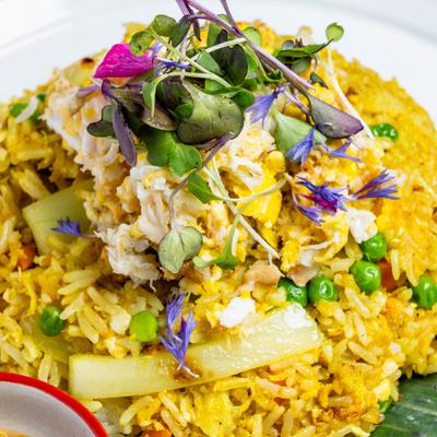 Crab fried rice with flower and microgreen garnish.