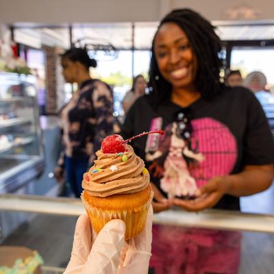 Employee giving a muffin to a customer.