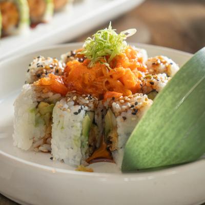 Volcano Roll arranged in a circle, with a spicy fish mixture and a circular leaf decoration.