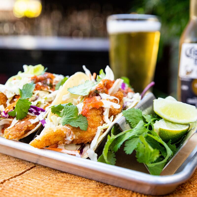 Fish tacos with avocado, draft beer and vegetables