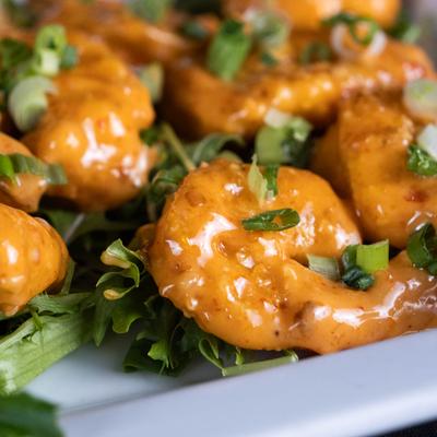 Fried shrimp in a creamy Sriracha sauce with green onion.