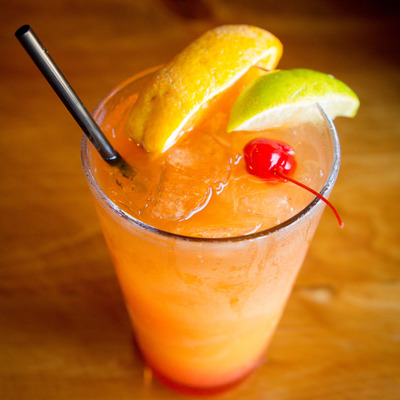 Orange cocktail with lemon lime and cherry