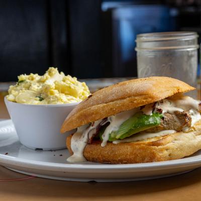 Chicken sandwich on ciabatta served with a side of potato salad.