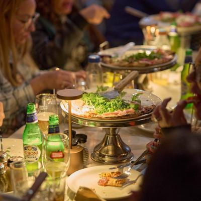 People dininhg at the table with various foods and drinks.