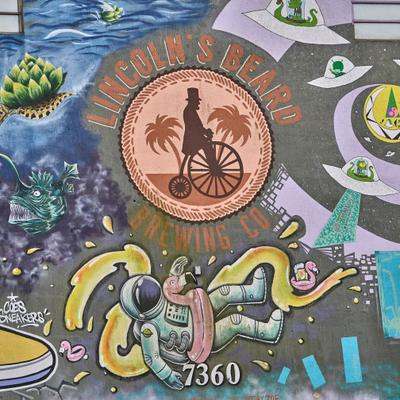 Wall mural depicting person riding a bicycle, flying saucers and an astronaut.