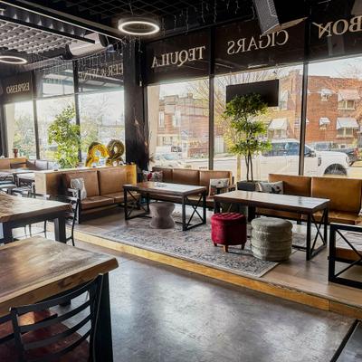 Interior, a modern industrial design with wooden tables and leather-style seating.