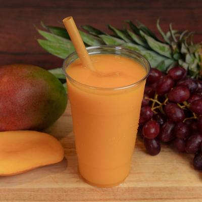 Mango smoothie cup accompanied with fresh fruits on the table.