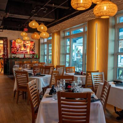 Empty restaurant dining room with wooden chairs and warm lighting.