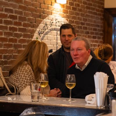 Guests at the bar enjoying wine and conversation.