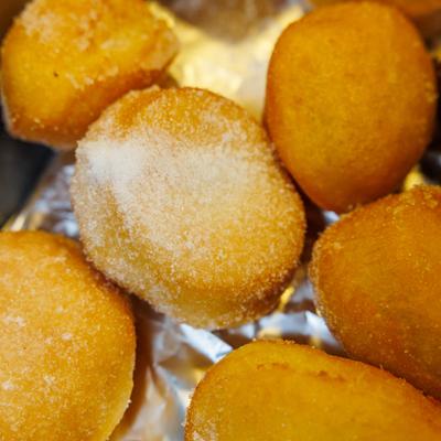 Sugar-coated fried dough balls on foil.