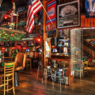 Cozy sports bar with wooden decor, colorful string lights, an American flag, sports memorabilia
