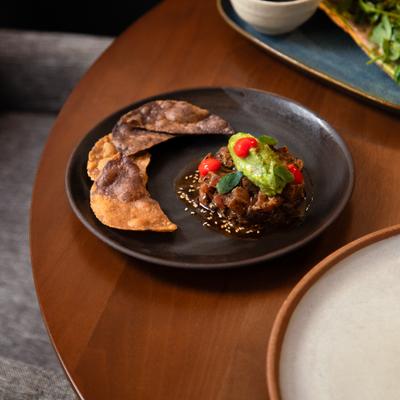 Beef tatare, topped with guacamole swrved with fried tortillas on the side.