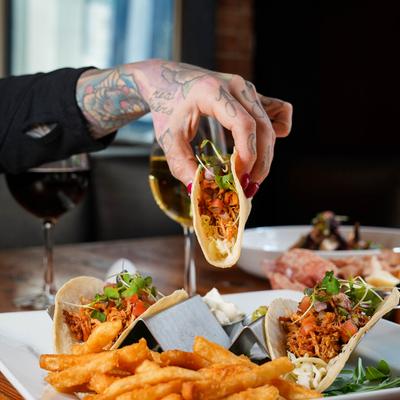 Hand holds chicken taco