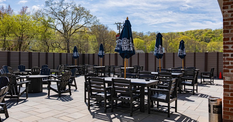 Wide view of outdoor seating area, tables and chairs with parasols