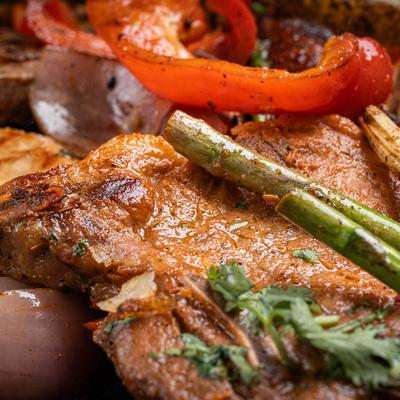 Close up of a cooked meat dish, served with vegetables.