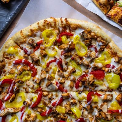 Buffalo Chicken Pizza with banana peppers, red peppers and blue cheese dressing.