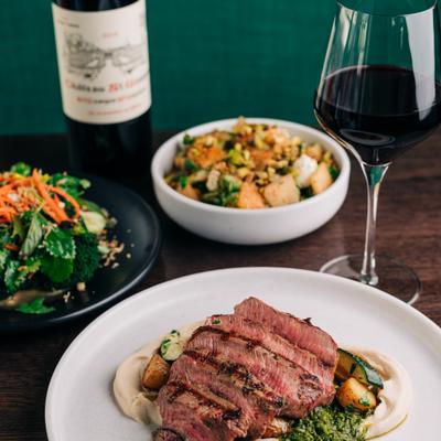 Multiple plates featuring Grilled Flat Iron* (GF, VA) img White Bean Hummus, Zucchini, Baby Potatoes, Zhoug.