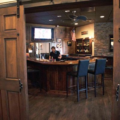 Bar with tall chairs, lady staff working