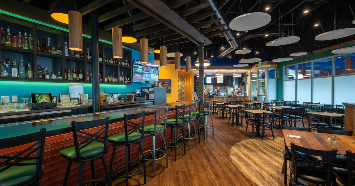 Interior, a bar on the left with tables and chairs on the right