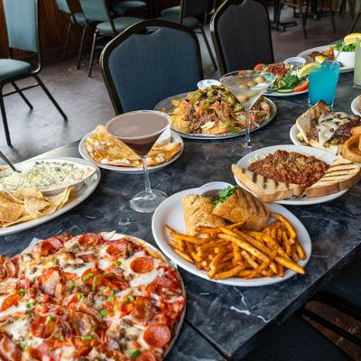Assorted food plates and cocktails arranged on a table.