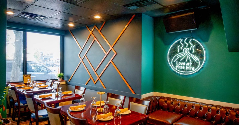 Interior, dining area, wooden top tables for two and four, leather padded three-seater sofa