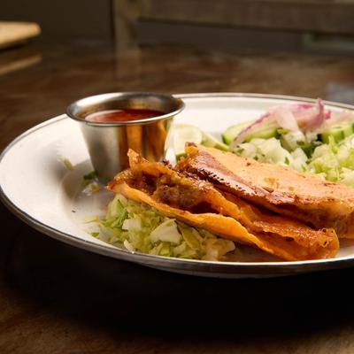 Quesabirria tacos, served with salad.