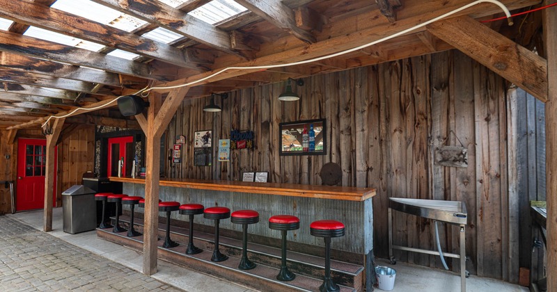 Exterior, covered patio, outdoor bar with padded stools, cobblestone paving