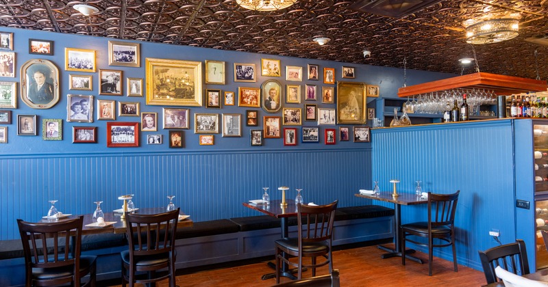Interior with blue walls, vintage photos and wooden furniture.