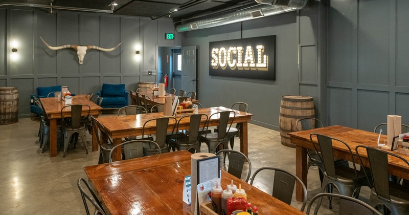Interior, dining area, wooden top tables for eight, concrete flooring, back entrance
