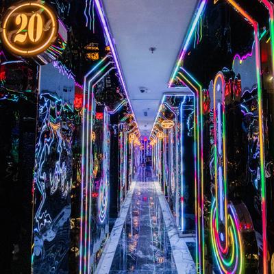 Long hallway with neon lights and reflective glossy walls.