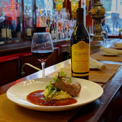 Steak and mashed potatoes served with a glass of wine.