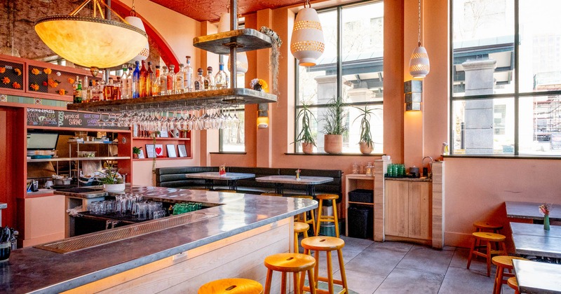Interior, bar and dining area, bar with stools, corner banquette bench with two tables