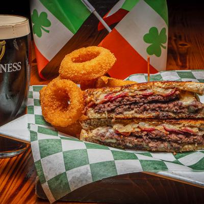 Rustic Reuben Sandwich, served with onion rings.