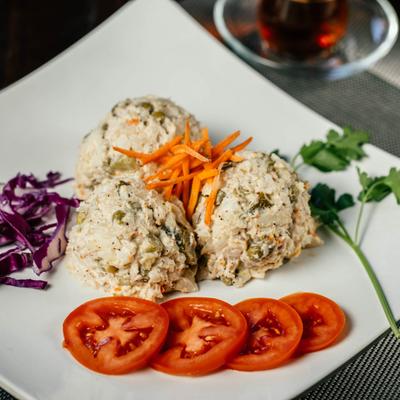 Chicken and potato salad, with tomato, purple cabbage, and carrots.