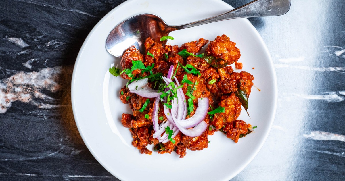 Chicken 65 topped with diced onion and herbs